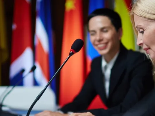 Two country leaders discussing with each other at a world political conference.