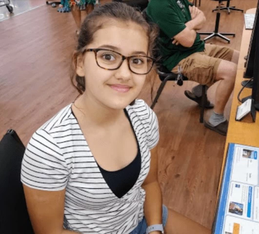 WHO student, Ruby, smiling and looking at the camera. 