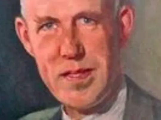 A close-up portrait painting of Wolsey Hall Oxford founder Joseph William Knipe. Joseph is smiling at the camera and is wearing a suit, with short grey hair.