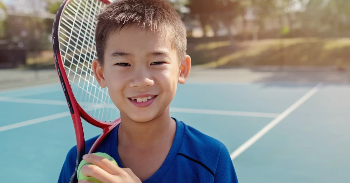 A young elite tennis player with his ball and racket in hand on the tennis court. 