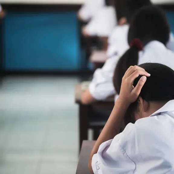 Student in an exam hall, taking an exam.