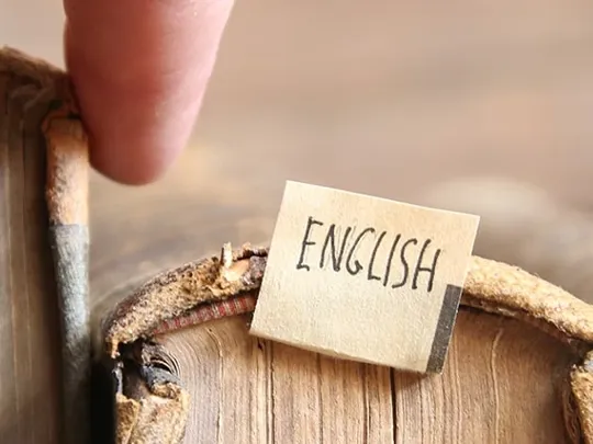 Old English books being pulled from a shelf.