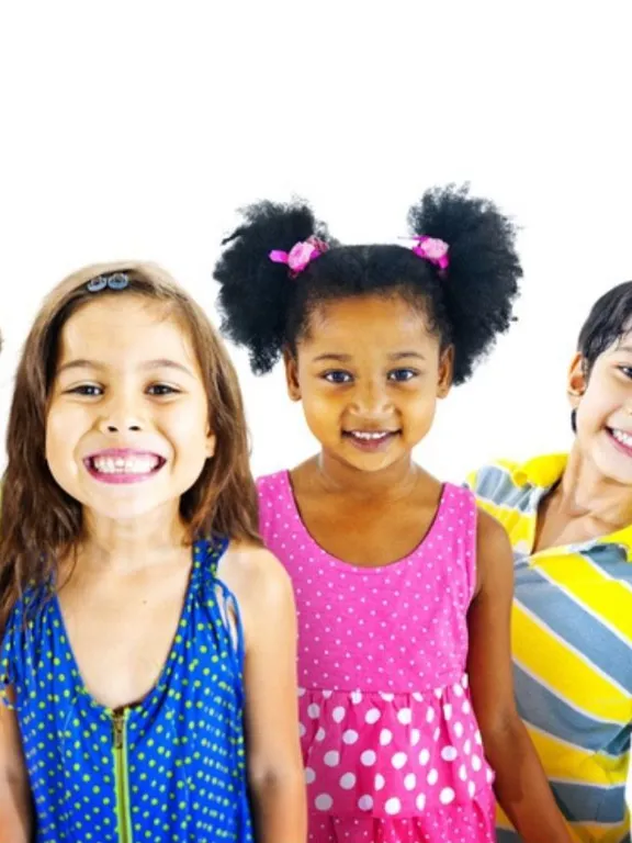 Line-up of cheerful children in brightly coloured clothes, smiling against a white background