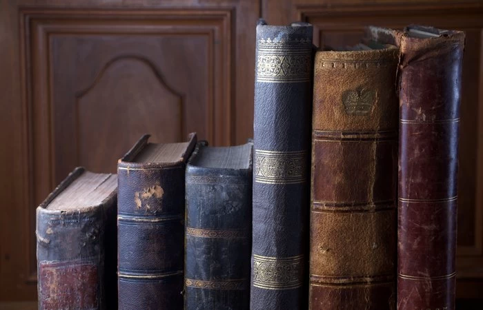 A variety of old English books of different sizes. 