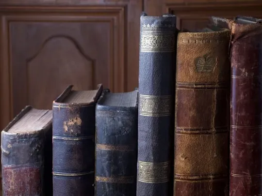 A variety of old English books of different sizes.