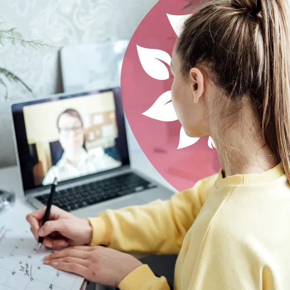 Student taking notes during a virtual lesson with a tutor on a laptop screen