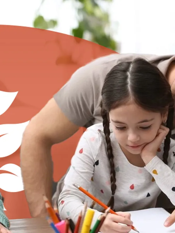 A dad homeschooling his two young daughters at a desk.