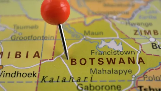 Close up of a map, with a pin in the country of Botswana.