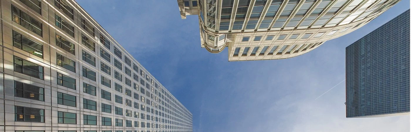 Looking towards the sky surrounded by high rise buildings. 