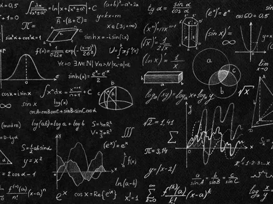 A blackboard with a variety of maths equations and symbols written on it.
