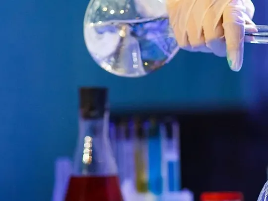 Scientist using science equipment in a chemistry experiment.