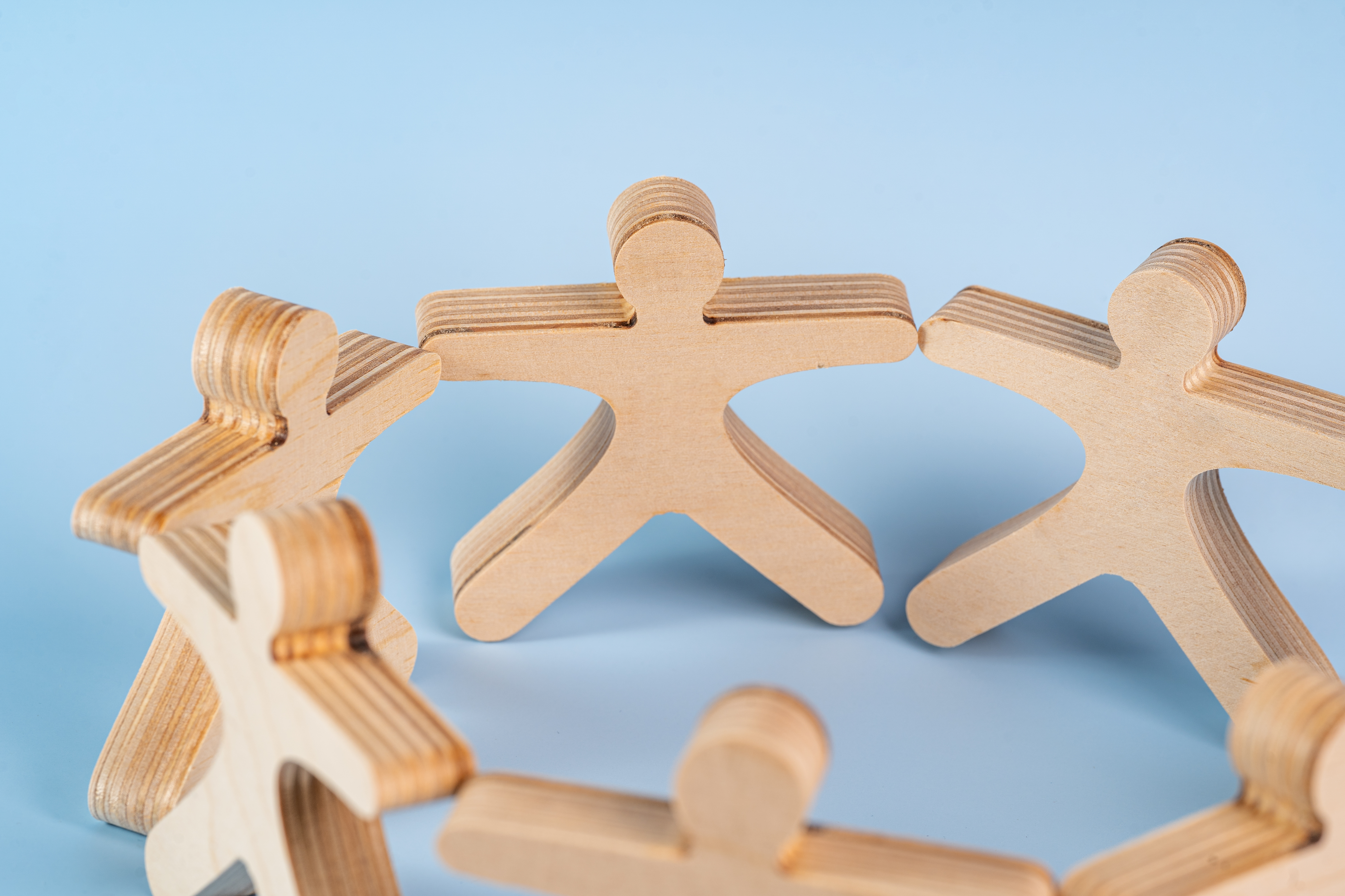 Wooden people holding hands. 