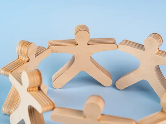 Wooden people holding hands.