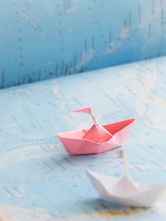Paper boats on a map.