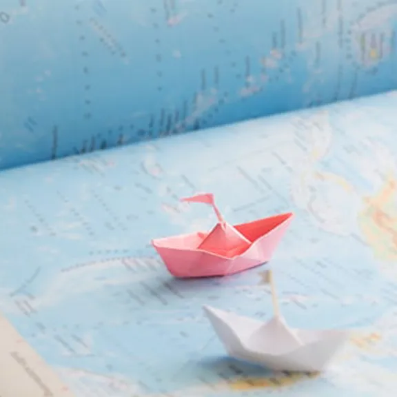 Paper boats on a map.