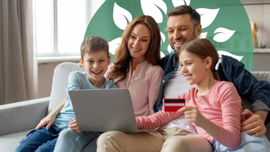 A happy family sitting together on the sofa, enrolling their children in an online school with a laptop.