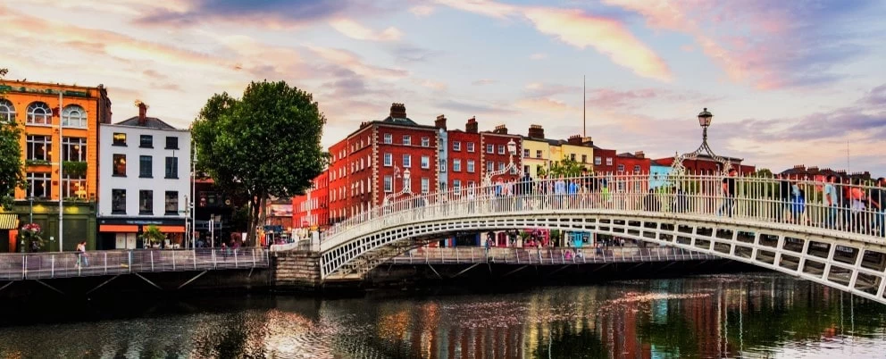 A landscape view of the Penny Bridge in Dublin, Ireland, with a scenic sky above it. 