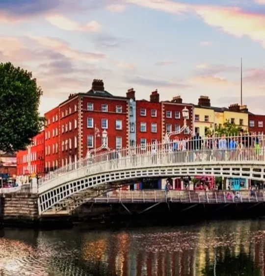 A landscape view of the Penny Bridge in Dublin, Ireland, with a scenic sky above it.
