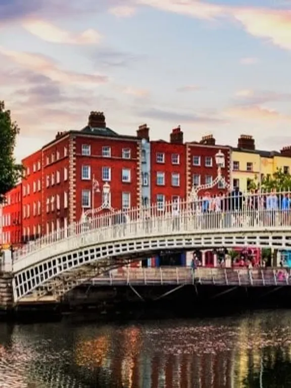 A landscape view of the Penny Bridge in Dublin, Ireland, with a scenic sky above it.