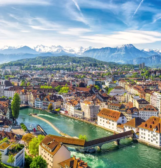 A landscape view of a Swiss village, on a clear day with the sun shining.