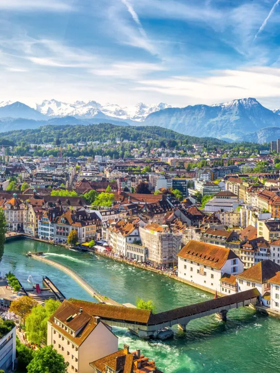 A landscape view of a Swiss village, on a clear day with the sun shining.