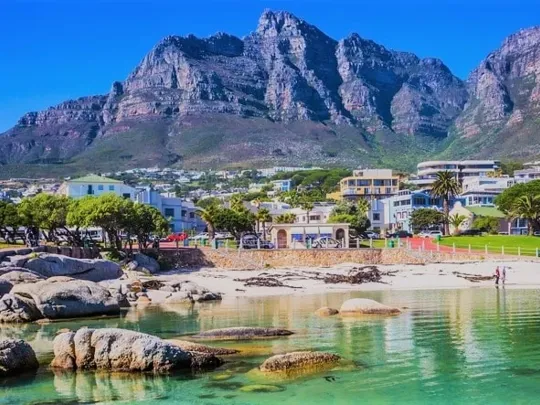 Scenic view of a beach and buildings in Cape Town with Table Mountain in the background.
