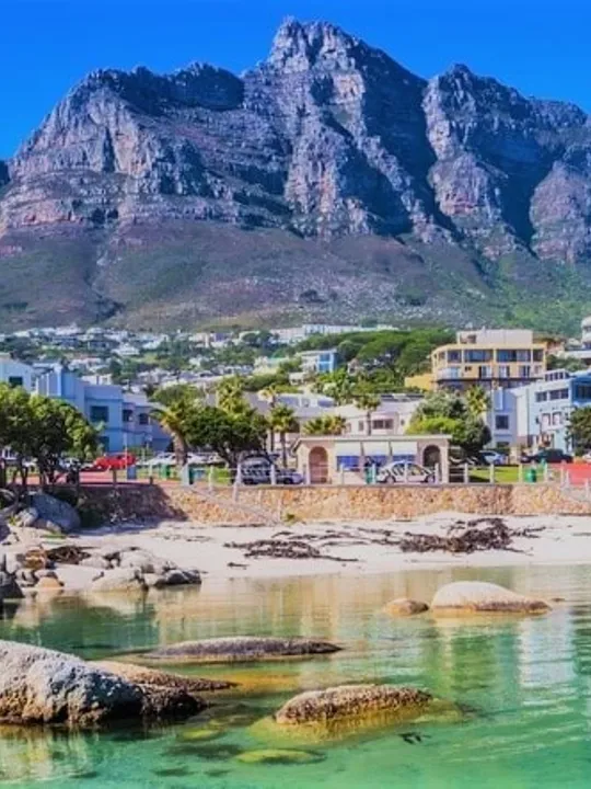 Scenic view of a beach and buildings in Cape Town with Table Mountain in the background.