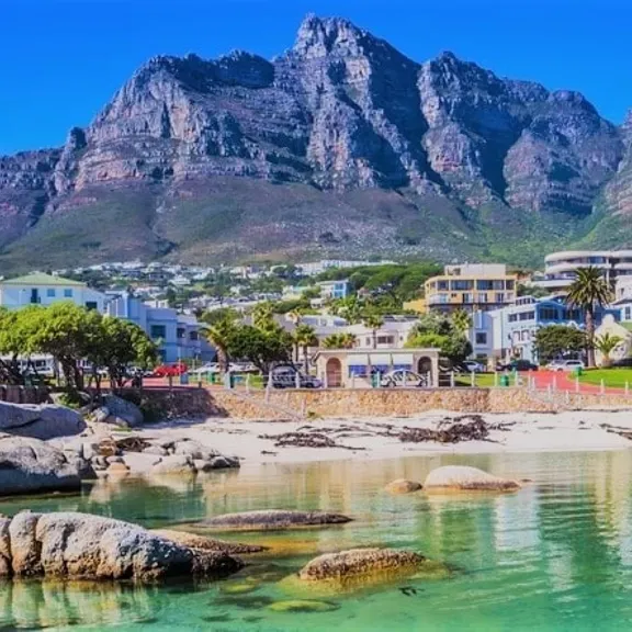 Scenic view of a beach and buildings in Cape Town with Table Mountain in the background.