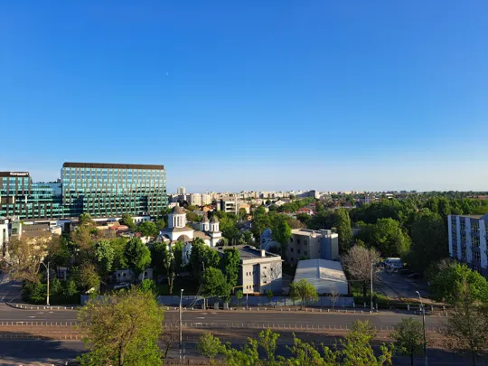 Cityscape of Bucharest, Romania, featuring a blend of modern buildings and leafy streets