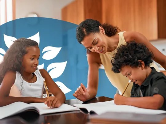 Smiling parent helping two children with their studies at the kitchen table.