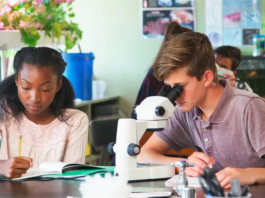 Students looking through a microscope.