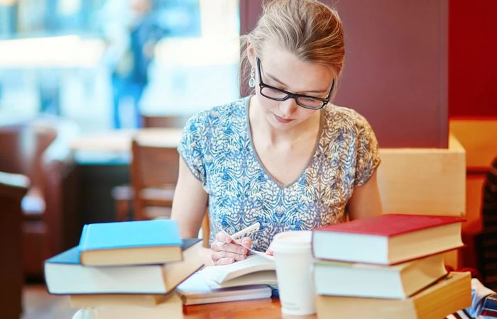 A woman reading in a parisian cafe. 
