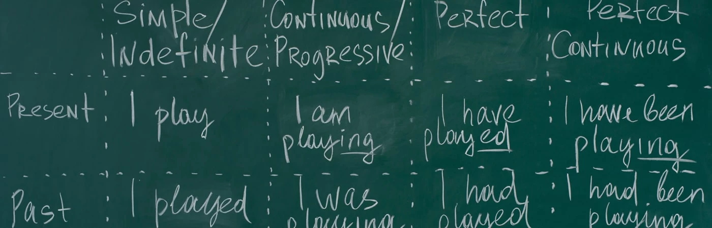 A blackboard with different English sentences and phrases on. 