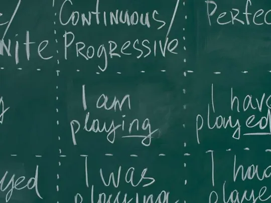A blackboard with different English sentences and phrases on.