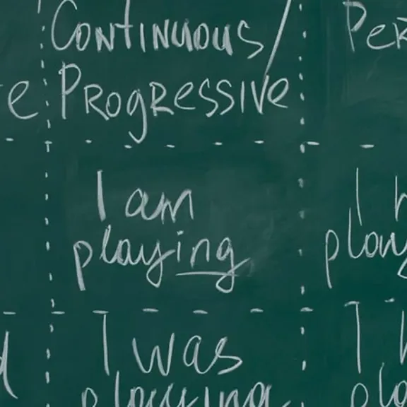 A blackboard with different English sentences and phrases on.