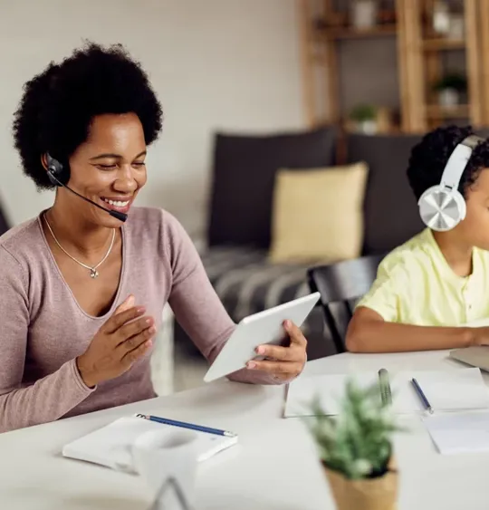 Mother working whilst son is studying close by.