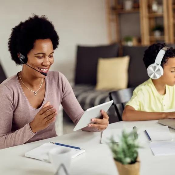 Mother working whilst son is studying close by.