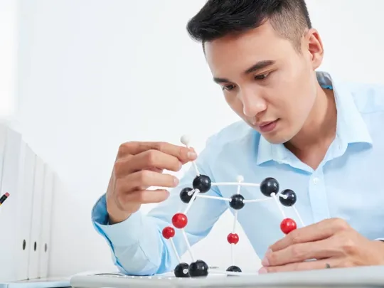 A chemistry student is examining a molecule model.