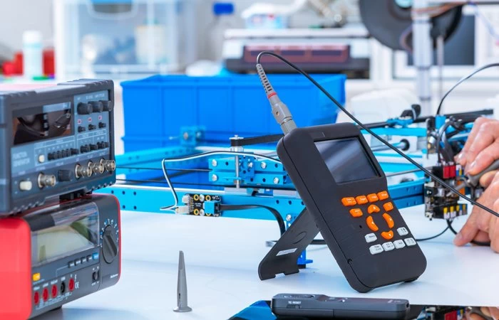 Students conducting an experiment to measure the level of electricity flow using scientific equipment. 