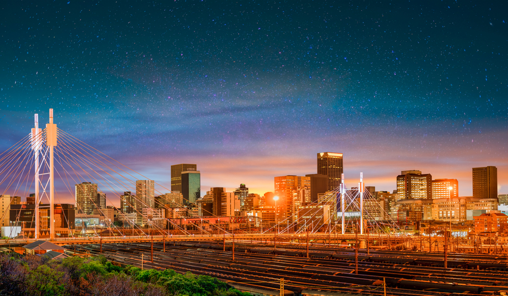 The vibrant Johannesburg skyline at dusk, including the Nelson Mandela Bridge, showcasing the dynamic environment for homeschooling families in the city.