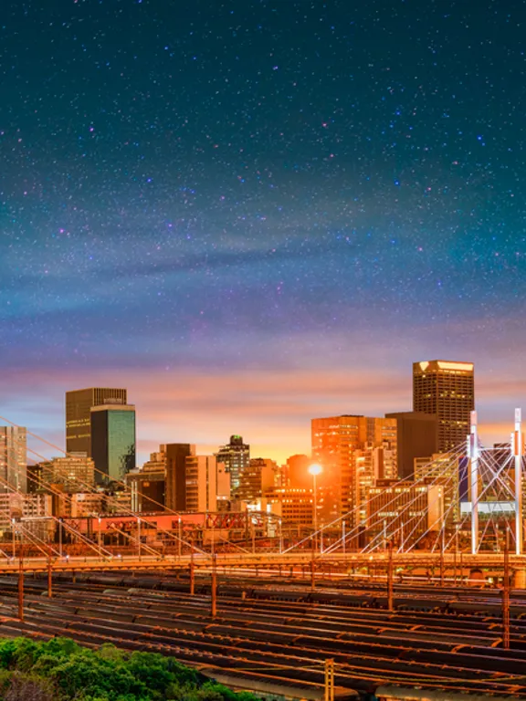 The vibrant Johannesburg skyline at dusk, including the Nelson Mandela Bridge, showcasing the dynamic environment for homeschooling families in the city.