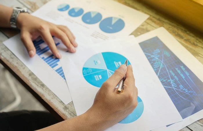 An individual analysing coloured data charts for business purposes. 