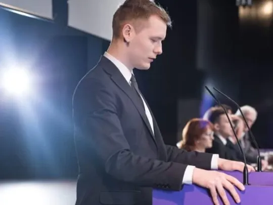 A country leader preparing to speak on a panel of other politicians.