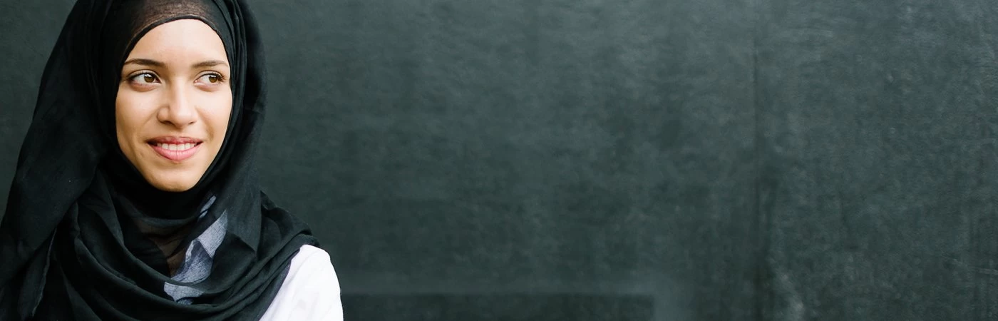 A woman standing against a black background. 