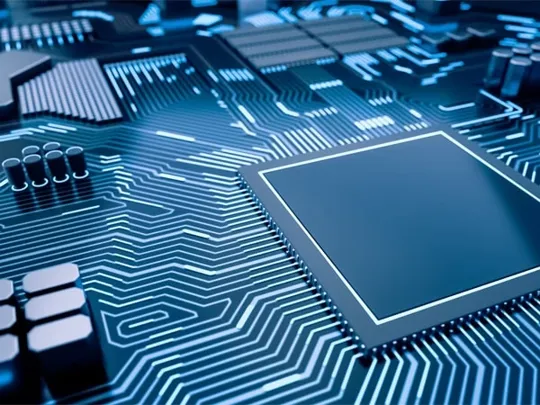 Close-up of a blue-toned computer circuit board representing advanced computer science technology.