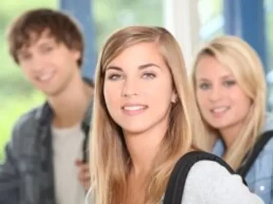 A photograph of one male and two female A Level students smiling at the camera.